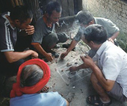 陰雨天,三五瑤民聚在一起玩瑤族傳統(tǒng)“趕豬棋”。